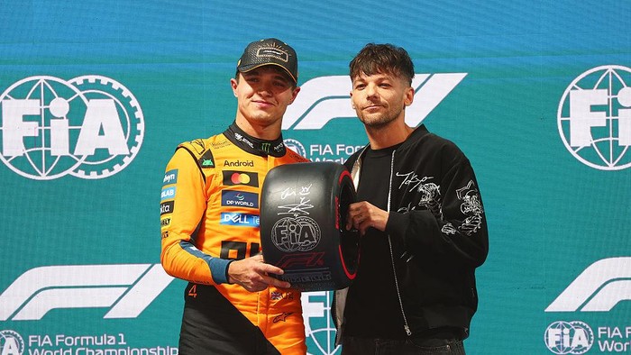 LAS VEGAS, NEVADA - NOVEMBER 21: Pole position qualifier Lando Norris of Great Britain and McLaren receives his Pirelli Pole Position award from Louis Tomlinson during qualifying ahead of the F1 Grand Prix of Las Vegas at Las Vegas Strip Circuit on November 21, 2025 in Las Vegas, Nevada. (Photo by Bryn Lennon - Formula 1/Formula 1 via Getty Images)