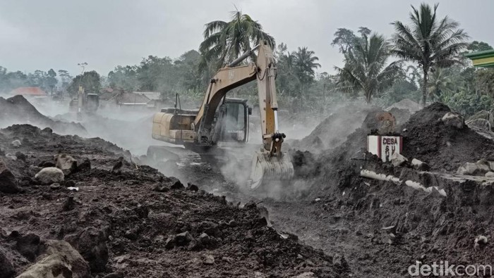 Alat berat membantu membersihkan jalanan dan rumah warga dari material sisa erupsi gunung semeru