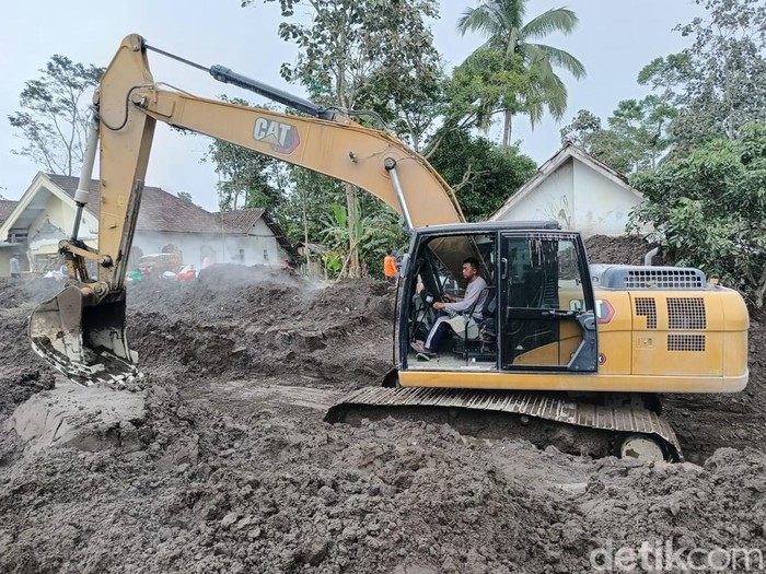 Alat berat membantu membersihkan jalanan dan rumah warga dari material sisa erupsi gunung semeru