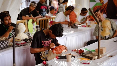 Para peserta membentuk anatomi wajah dalam bentuk topeng ogoh-ogoh yang dilombakan di Puspem Badung, Sabtu (22/11/2025).