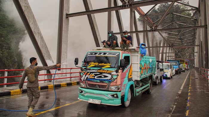 Sejumlah petugas berjaga di Jembatan Besuk Kobokan, Kecamatan Candipuro, Lumajang, Jawa Timur, Sabtu (22/11/2025). Pemerintah Kabupaten Lumajang menyiagakan tim gabungan untuk memberikan keamanan bagi pengendara yang melintas di kawasan tersebut menyusul risiko hujan abu dan potensi letusan sekunder dari aktivitas Erupsi Semeru. ANTARA FOTO/Irfan Sumanjaya/YU