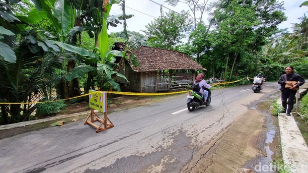 Ruas jalan di Sompok, Sriharjo, Imogiri, Bantul yang retak tampak dipasangi garis polisi, Sabtu (22/11/2025).