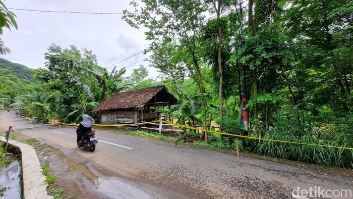 Ruas jalan di Sompok, Sriharjo, Imogiri, Bantul yang retak tampak dipasangi garis polisi, Sabtu (22/11/2025).