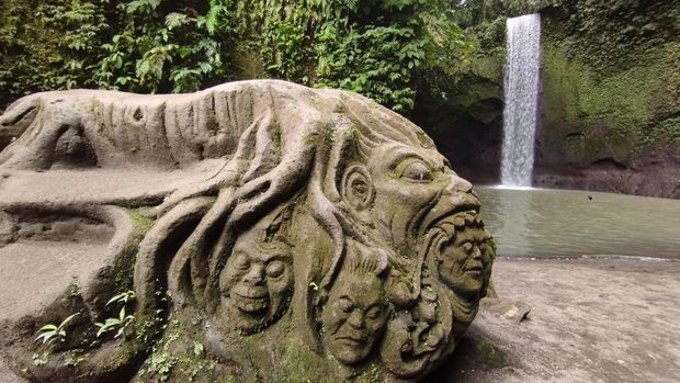 Tempat Berfoto Wisatawan di Air Terjun Tibumana Salah satu tempat berfoto di Air Terjun Tibumana, Bangli, Bali, Sabtu (15/11/2025). Wisatawan berdiri di atas batu berukir dan berfoto dengan latar air terjun.