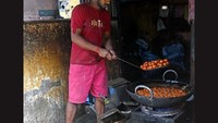 Di sudut dapur, seorang juru masak menggoreng bola keju lalu merendamnya dalam air mawar dan sirup, menghasilkan gulab jamun khas Bengali yang segar. Foto: Amit Datta/Telegraph India