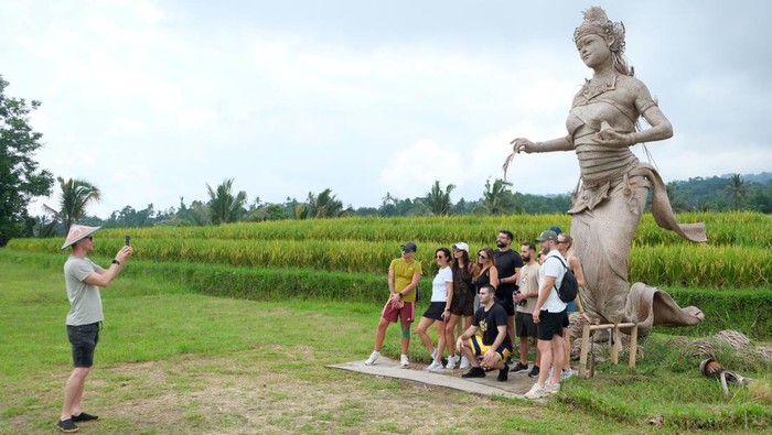 Wisatawan mancanegara berfoto bersama di area patung Dewi Sri berbahan bambu saat berkunjung di Desa Wisata Jatiluwih, Tabanan, Bali, Minggu (23/11/2025). Pengelola mencatat jumlah kunjungan wisatawan di desa wisata yang meraih penghargaan internasional sebagai salah satu destinasi berkelanjutan terbaik dunia dalam ajang Green Destinations Top 100 Stories 2025 yang digelar di Montpellier, Prancis itu selama periode 1 Januari hingga 22 November 2025 berjumlah 358.001 orang dengan rincian yakni 99.279 wisatawan nusantara dan 258.722 wisatawan mancanegara yang didominasi wisatawan asal negara-negara Eropa. ANTARA FOTO/Nyoman Hendra Wibowo/bar