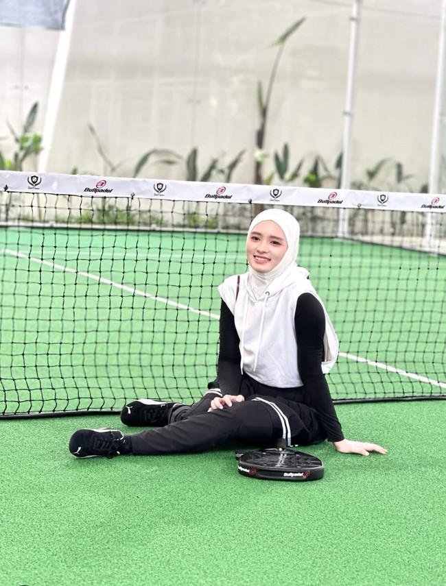 Inara memilih memadukan atasan crop top hoodie tanpa lengan berwarna putih dengan dalaman lengan panjang hitam. Untuk bawahannya ia mengenakan pleated skirt hitam dipadukan celana panjang senada. Penampilannya makin lengkap dengan hijab putih. Foto: Instagram/@mommy_starla
