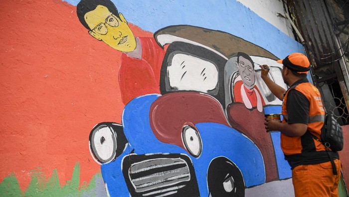 Petugas Penanganan Prasarana dan Sarana Umum (PPSU) membuat mural di Kelurahan Pademangan Barat, Jakarta, Minggu (23/11/2025). Pembuatan mural itu merupakan bagian dari penataan kawasan agar tidak terlihat kumuh dan menjadi sasaran vandalisme. ANTARA FOTO/Muhammad Adimaja/tom.