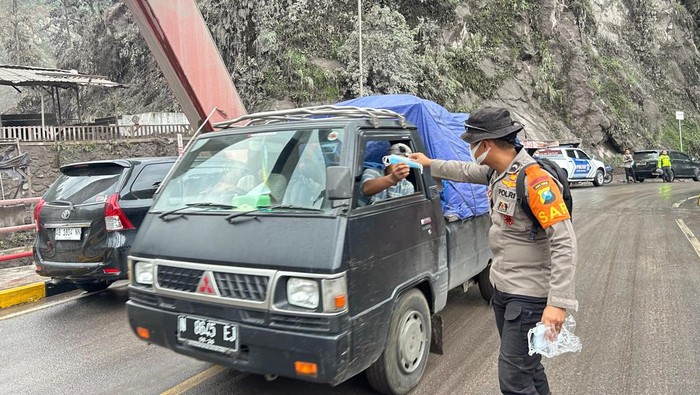 Tim SAR Polda Jatm memberikan masker pada pengendara yang melewati jembatan Gladak Perak Minggu (23/11/2025)