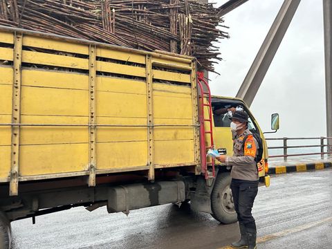 Tim SAR Polda Jatm memberikan masker pada pengendara yang melewati jembatan Gladak Perak Minggu (23/11/2025)