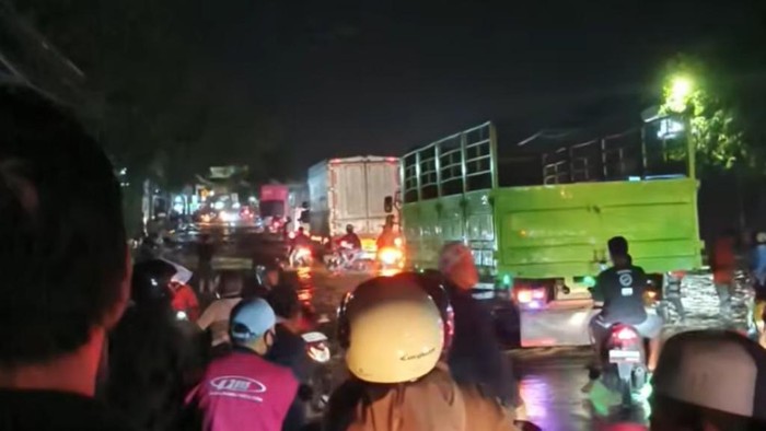 Banjir di Jalan Raya Tambakrejo, Kraton, Pasuruan setinggi setengah sepeda motor. Mobil dan kendaraan roda 4 lainnya dialihkan ke tol.