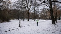 Seseorang berjalan di Volkspark Friedrichshain, setelah hujan salju melanda ibu kota Jerman, Berlin, Senin (24/11/2025). REUTERS/Annegret Hilse