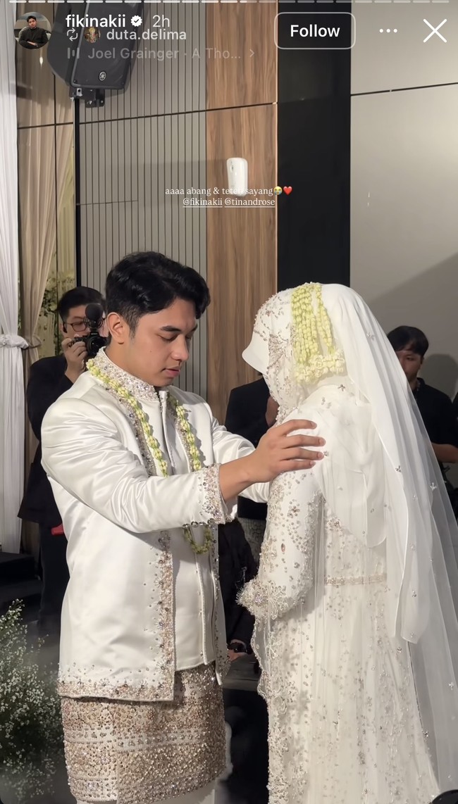 Sementara pengantin wanita mengenakan kebaya putih dengan detail bordir dan payet. Penampilannya semakin lengkap dengan hijab dan cadar, serta rangkaian melati di kepalanya. Foto: Instagram/@fikinakii
