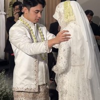 Sementara pengantin wanita mengenakan kebaya putih dengan detail bordir dan payet. Penampilannya semakin lengkap dengan hijab dan cadar, serta rangkaian melati di kepalanya. Foto: Instagram/@fikinakii