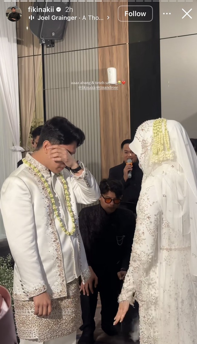 Fiki Naki juga sempat terlihat ikut terharu hingga tak sanggup menahan air matanya. Di salah satu unggahan tampak Fiki yang sedang berhadapan dengan Tinandrose yang sudah sah menjadi istrinya. Ia tampak menyeka matanya karena sedikit menangis terharu. Foto: Instagram/@fikinakii