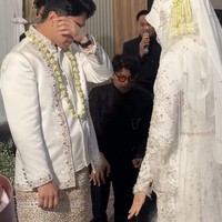 Fiki Naki juga sempat terlihat ikut terharu hingga tak sanggup menahan air matanya. Di salah satu unggahan tampak Fiki yang sedang berhadapan dengan Tinandrose yang sudah sah menjadi istrinya. Ia tampak menyeka matanya karena sedikit menangis terharu. Foto: Instagram/@fikinakii