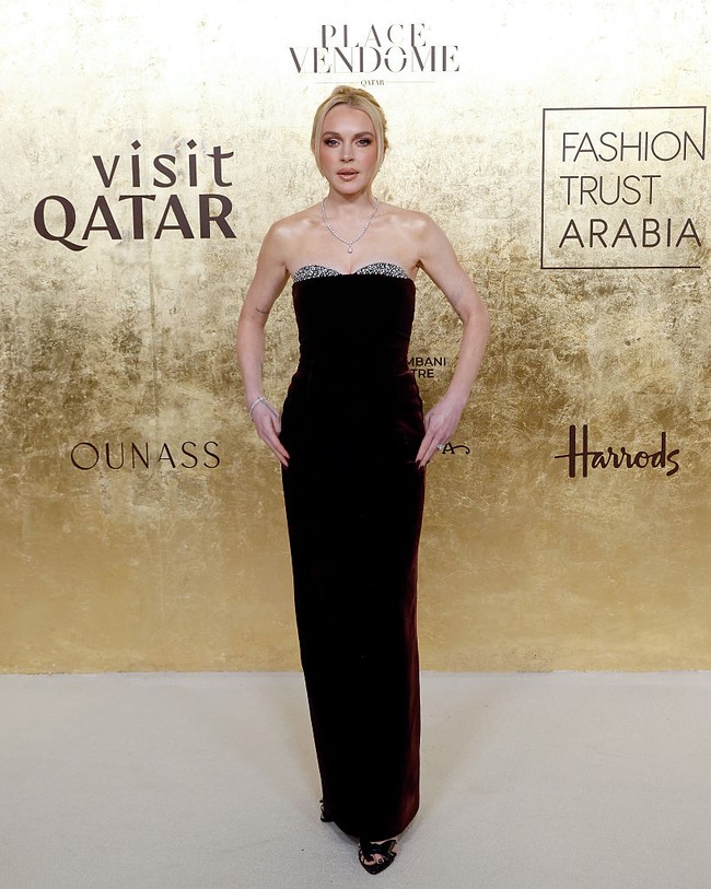 Lindsay Lohan memancarkan pesona klasik melalui gaun beludru cokelat gelap yang membalut tubuhnya dengan anggun. Gaun beraksen bra berhias permata itu dipadukan dengan sandal hitam berujung terbuka. Rambut pirang kemerahannya ditata rapi dalam gaya sanggul, menegaskan kesan mewah di karpet merah. (Foto: Taylor Hill/Getty Images)