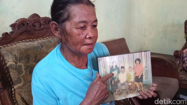 Kakak ipar Seni, Walmi (60) menunjukan foto Seni saat muda (memakai kaus warna tosca) bersama kakaknya serta kedua orangtuanya yang masih disimpan hingga sekarang, Senin (24/11/2025).