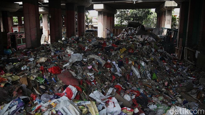 Pekerja beraktivitas di tempat pembuangan sementara (TPS) sampah di kolong Tol Wiyoto Wiyono, Sungai Bambu, Tanjung Priok, Jakarta Utara, Senin, (24/11/2025). Warga sekitar mengeluhkan kehadiran TPS tersebut karena kenaikan volume sampah dari hari ke hari menyebabkan bau tak sedap dan kualitas lingkungan menurun. Status TPS tersebut juga masih kontroversial karena tidak diperkenankan ada bangunan atau aktivitas permanen di kolong tol.