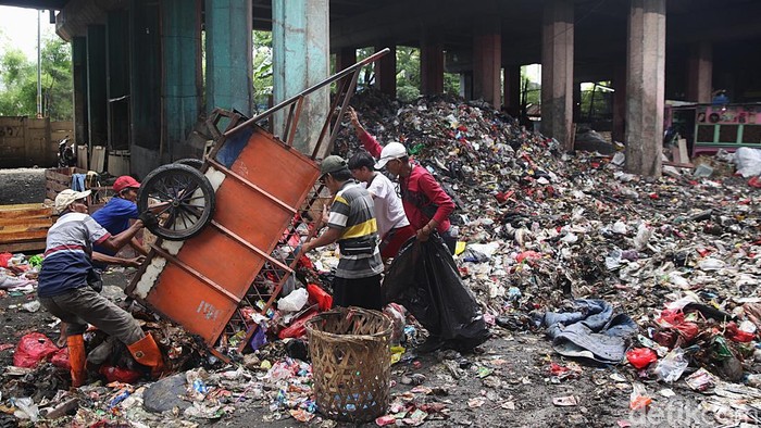 Pekerja beraktivitas di tempat pembuangan sementara (TPS) sampah di kolong Tol Wiyoto Wiyono, Sungai Bambu, Tanjung Priok, Jakarta Utara, Senin, (24/11/2025). Warga sekitar mengeluhkan kehadiran TPS tersebut karena kenaikan volume sampah dari hari ke hari menyebabkan bau tak sedap dan kualitas lingkungan menurun. Status TPS tersebut juga masih kontroversial karena tidak diperkenankan ada bangunan atau aktivitas permanen di kolong tol.