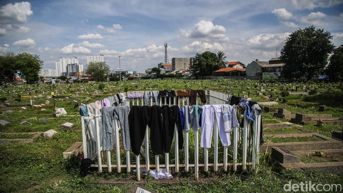 Sejumlah warga berktivitas di kawasan TPU Kober Rawa Bunga, Jatinegara, Jakarta Timur, Senin (24/11/2025).