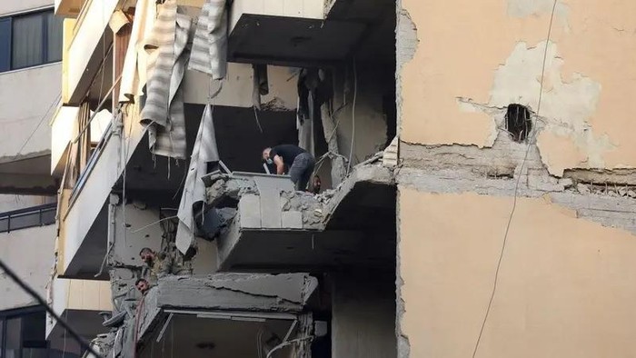 People inspect a damaged building, after an Israeli strike, in Beirut’s southern suburbs, Lebanon, November 23, 2025. (Reuters)