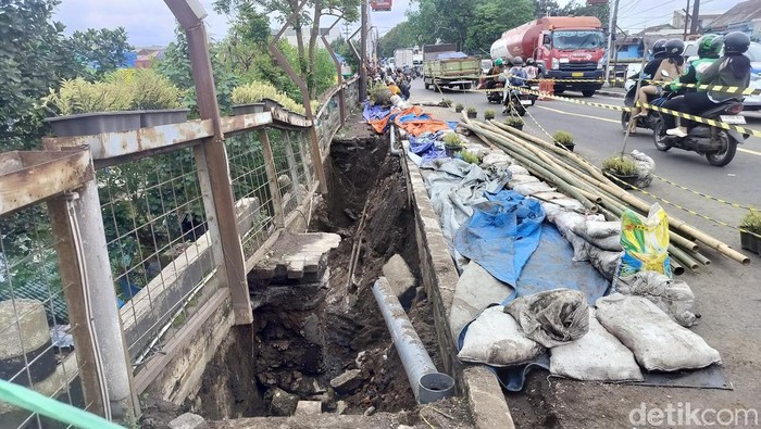 Trotoar amblas diatas jembatan Brantas dan petugas mengatur arus lalin
