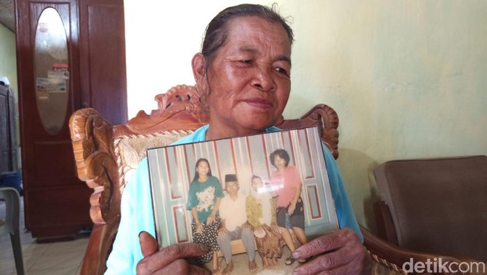 Kakak ipar Seni, Walmi (60), saat menunjukkan foto Seni.