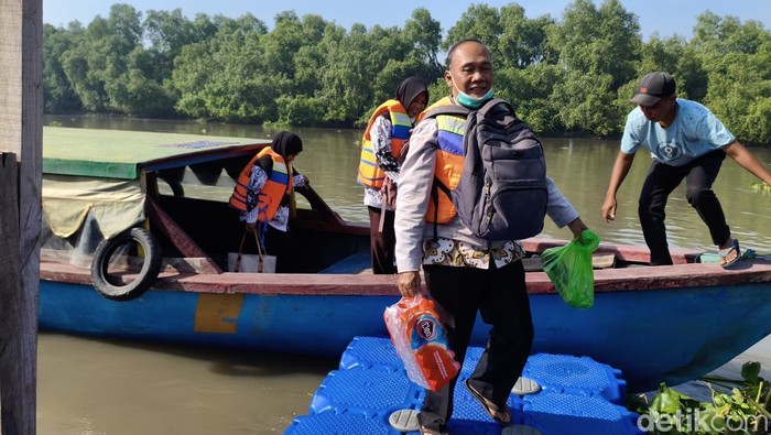 Ahmad Fadholi saat berangkat mengajar di SD negeri terpencil Dusun Kepentingan Sawohan Sidoarjo