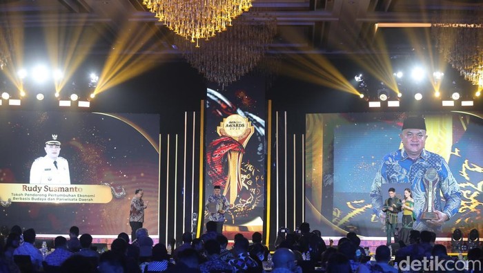 Bupati Bogor Rudy Susmanto menerima penghargaan sebagai Tokoh Pendorong Pertumbuhan Ekonomi Berbasis Budaya dan Pariwisata Daerah dalam detikcom Awards 2025 di Westin Hotel Kuningan, Jakarta, Selasa 25 November 2025.