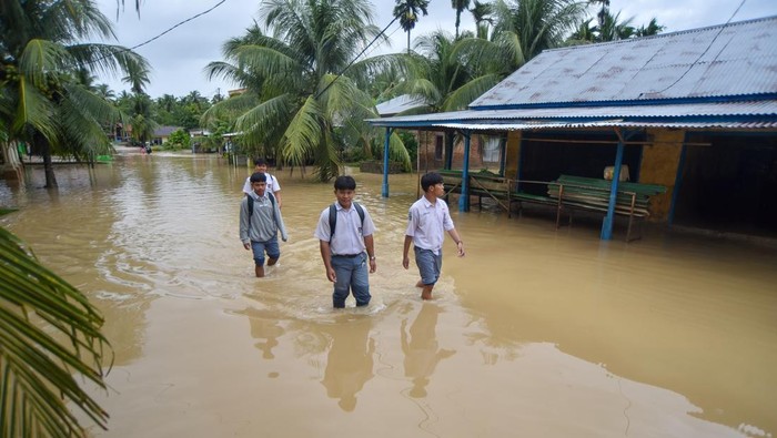 Warga berada di tepi jalan penghubung antar desa yang longsor akibat luapan sungai di Nagari Salibutan, Lubuk Alung, Padang Pariaman, Sumatera Barat, Selasa (25/11/2025). Berdasarkan data BPBD Padang Pariaman, sebanyak 3.076 unit rumah terendam banjir luapan sungai, dengan total warga terdampak mencapai 3.076 KK / 9.228 jiwa di 15 nagari sejak Senin (24/11/2025) dan terus meluas akibat intensitas hujan tinggi yang menyebabkan pemerintah daerah menetapkan status siaga darurat banjir dan longsor. ANTARA FOTO/Iggoy el Fitra/bar