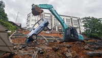 Operator mengoperasikan alat berat, mengangkat sebuah mobil yang terdampak longsor di kampus UIN Imam Bonjol Sungai Bangek, Padang, Sumatera Barat, Selasa (25/11/2025). ANTARA FOTO/Iggoy el Fitra