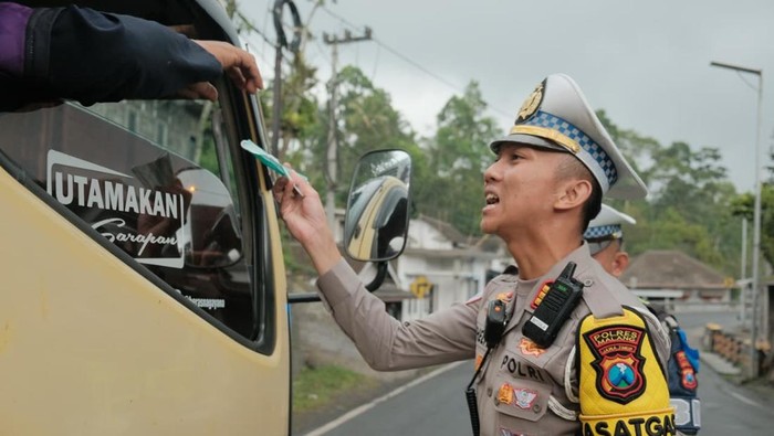 Petugas membagikan masker bagi pengguna jalan di perbatasan Malang-Lumajang.