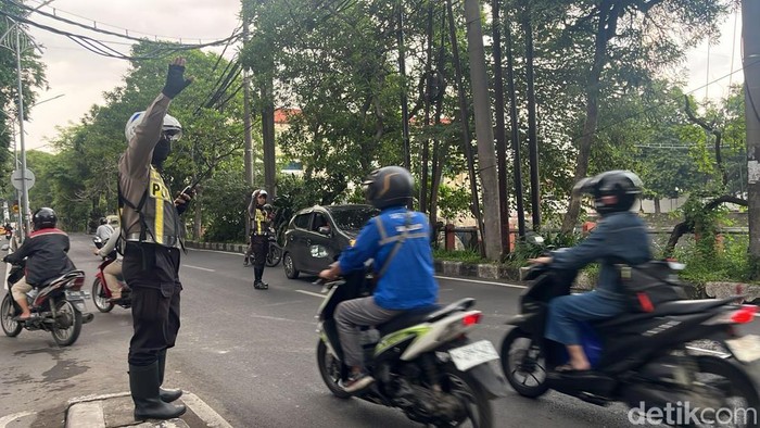 Polisi mengatur lalu lintas di Jalan Jagir Wonokromo saat demo truk odol sempat blokade satu jalur.