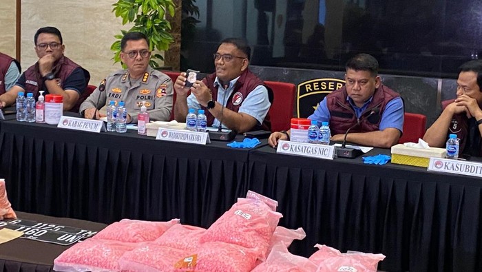 Polisi menyita sejumlah barang bukti kurir ratusan ribu ekstasi senilai Rp 207 miliar yang kecelakaan di Tol Lampung. Lencana Polri palsu termasuk yang disita. (Wildan N/detikcom)