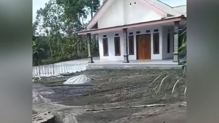 Sebuah rumah tampak utuh di antara rumah-rumah lain di dekatnya yang rusak diterjang awan panas guguran bahkan tenggelam oleh abu vulkanis saat Semeru erupsi.