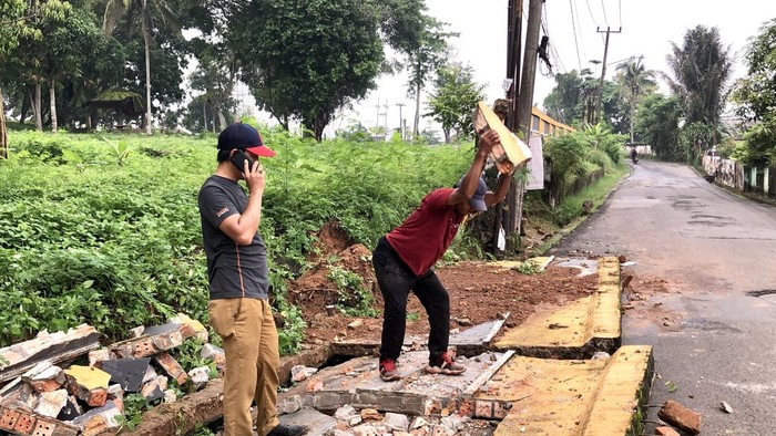 Warga saat membersihkan pagar yang roboh di Bukit Siguntang.