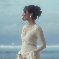 Alyssa mengenakan gaun panjang berwarna putih gading dengan bahan jatuh yang lembut, memberikan kesan elegan dan anggun. Gaun tersebut memiliki aksen lace di bagian kerah V-neck, dada, hingga pinggang, menambah nuansa feminin. Lengan gaun berbentuk flare di bagian ujung, memberi sentuhan klasik. Foto: Instagram/@alyssadaguise