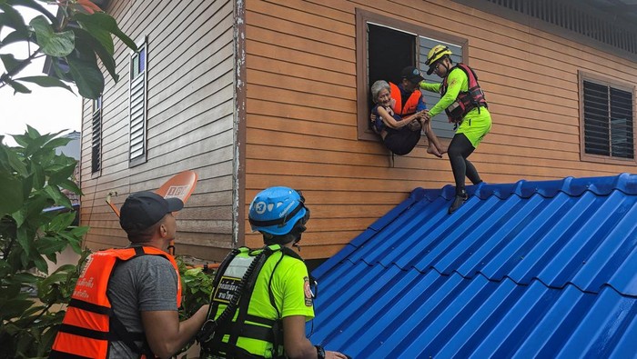 Rescuers evacuate local residents from their homes, which are partially submerged in a flooded area in Hat Yai district, affected by heavy rainfall, which has impacted several provinces in southern Thailand and has killed several people, in Songkhla province, Thailand, November 25, 2025. REUTERS/Sithichai Chootochan