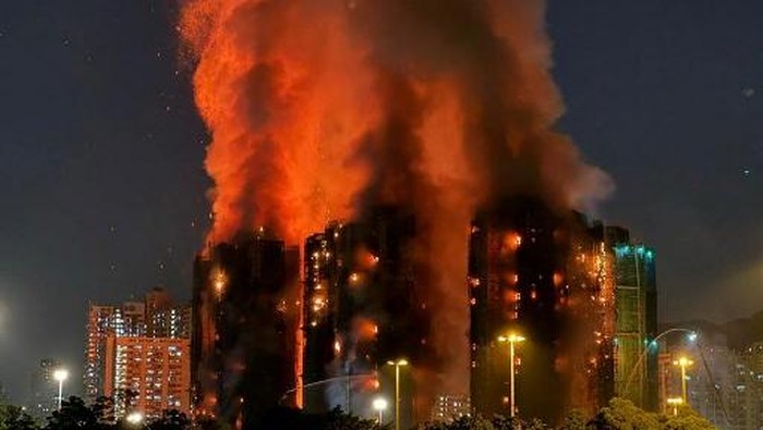 Thick smoke and flames rise as a major fire engulfs several apartment blocks at the Wang Fuk Court residential estate in Hong Kongs Tai Po district on November 26, 2025. At least four people were killed when a fire engulfed several high-rise blocks in a Hong Kong residential estate on November 26, the government said, with media reporting that some residents were trapped inside. (Photo by Yan ZHAO / AFP)