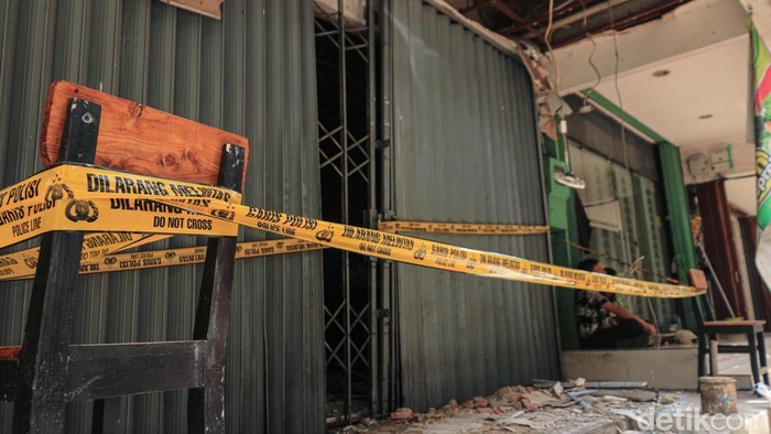 Warga melihat memeriksa area ruko yang terdampak ledakan di Jalan Raya Boulevard Barat Blok LA, Kelapa Gading, Jakarta Utara, pada Rabu (26/11/2025). Ledakan yang diduga berasal dari tabung gas ini menyebabkan kerusakan pada ruko