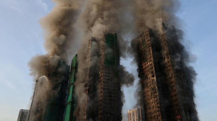Kebakaran besar melanda perancah bambu di beberapa gedung perumahan Wang Fuk Court, Tai Po, Hong Kong, pada Rabu (26/11/2025). Api dengan cepat menjalar di sepanjang rangka bambu bertingkat yang terpasang di sisi luar bangunan, memicu kepulan asap pekat yang menyelimuti kawasan permukiman. REUTERS/Tyrone Siu