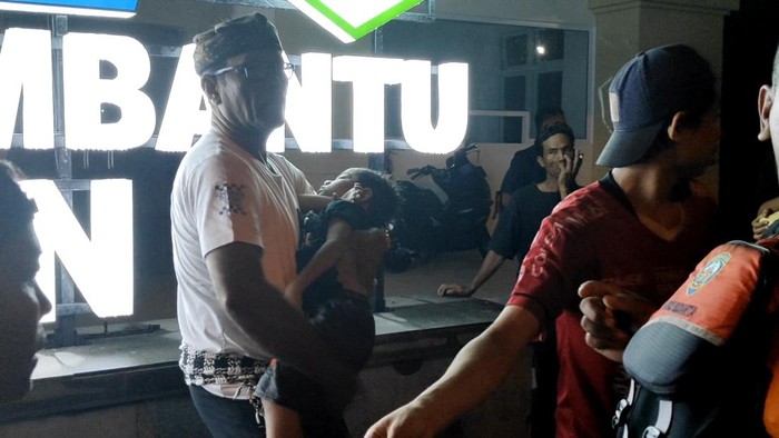Perbekel Mengwitani, I Nyoman Suardana, membantu mengevakuasi jasad bocah 4 tahun yang terseret arus saluran irigasi, Rabu (26/11/2025). (Agus Eka/detikBali)