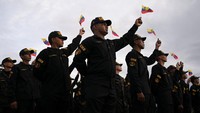 Anggota Komando Nasional Anti-Pemerasan dan Penculikan (CONAS) melambaikan bendera nasional Venezuela saat mereka mengikuti unjuk rasa menentang kemungkinan eskalasi tindakan Amerika Serikat terhadap negara tersebut. REUTERS/Gaby Oraa