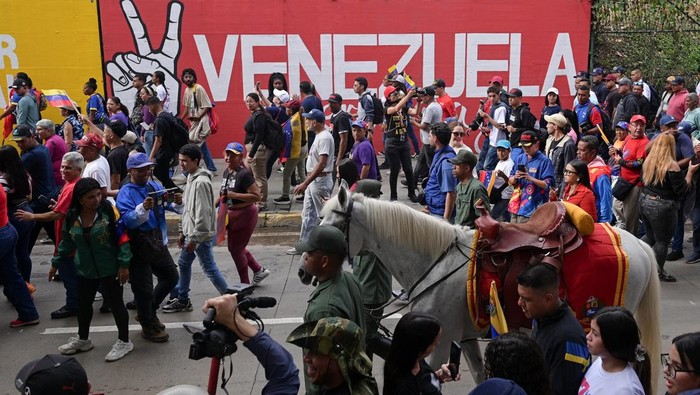 People take part in a rally against a possible escalation of U.S. actions toward the country, in Caracas, Venezuela, November 25, 2025. REUTERS/Gaby Oraa