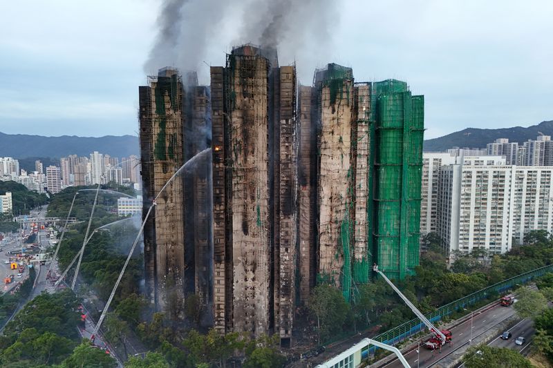 An injured firefighter boards an ambulance after being rescued from the scene of a major fire at Wang Fuk Court housing estate, in Tai Po, Hong Kong, China, November 27, 2025. REUTERS/Tyrone Siu