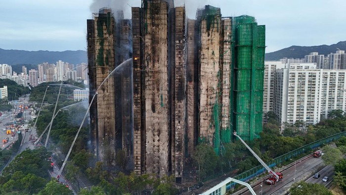 An injured firefighter boards an ambulance after being rescued from the scene of a major fire at Wang Fuk Court housing estate, in Tai Po, Hong Kong, China, November 27, 2025. REUTERS/Tyrone Siu
