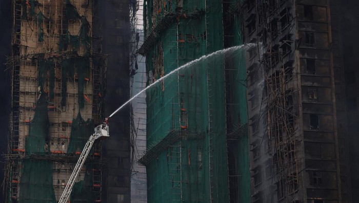 An injured firefighter boards an ambulance after being rescued from the scene of a major fire at Wang Fuk Court housing estate, in Tai Po, Hong Kong, China, November 27, 2025. REUTERS/Tyrone Siu