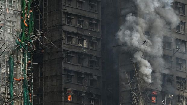 Apartments still burn as a major fire swept through several apartment blocks at the Wang Fuk Court residential estate in Hong Kong's Tai Po district on November 27, 2025. Firefighters were still dousing a devastating fire on November 27 which ripped through a Hong Kong high-rise complex, killing at least 44 people and leaving hundreds missing according to authorities. (Photo by Peter PARKS / AFP)