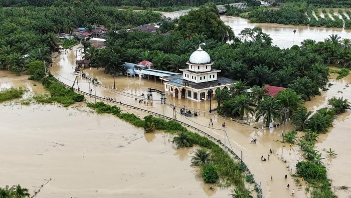 Foto udara pengendara melintasi jalan nasional Medan-Banda Aceh yang terendam banjir di Desa Peuribu, Arongan Lambalek, Aceh Barat, Aceh, Kamis (27/11/2025). Bencana banjir yang melanda 16 kabupaten/kota di Aceh selain berdampak pada ratusan ribu warga juga merusak sejumlah badan jalan dan jembatan sehingga memutuskan akses transpotasi darat. ANTARA FOTO/Syifa Yulinnas